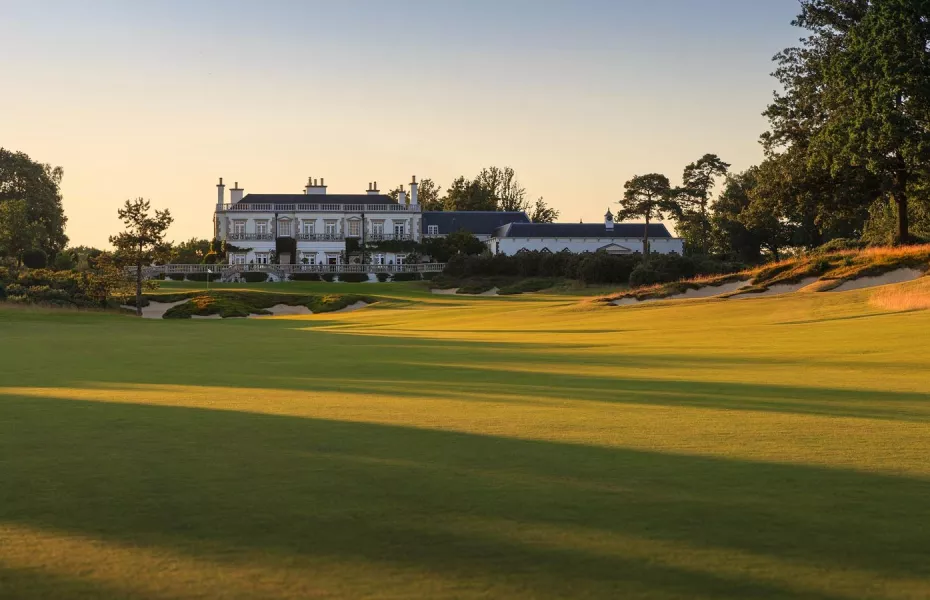 a large green field with a building in the background