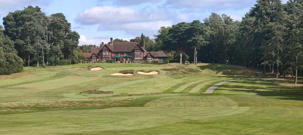 a large building with a large lawn and sand bunkers