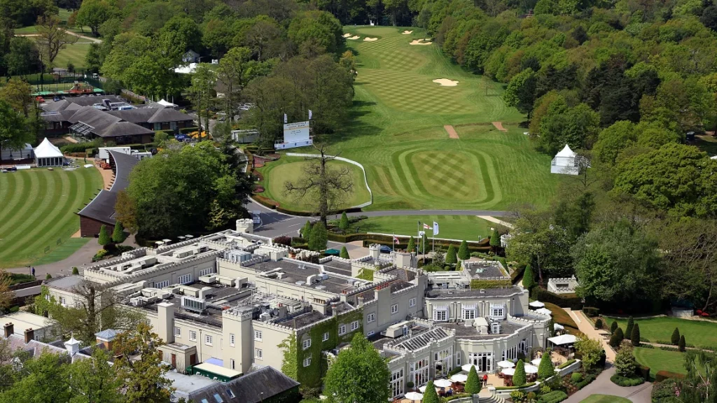 a large building with a golf course and trees
